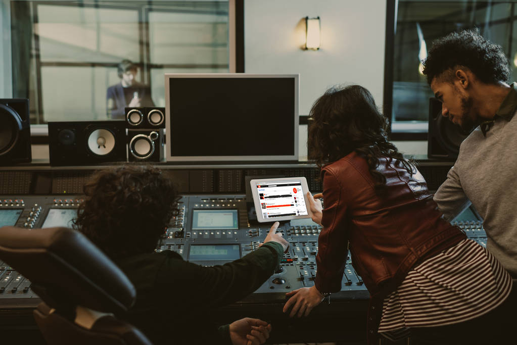 producteurs sonores utilisant la tablette ensemble au studio d'enregistrement avec site Web soundcloud à l'écran
 - Photo, image