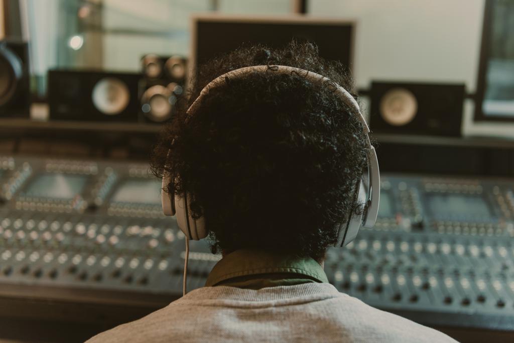 πίσω όψη του ήχου παραγωγός ακουστικά που κάθεται στο studio - Φωτογραφία, εικόνα