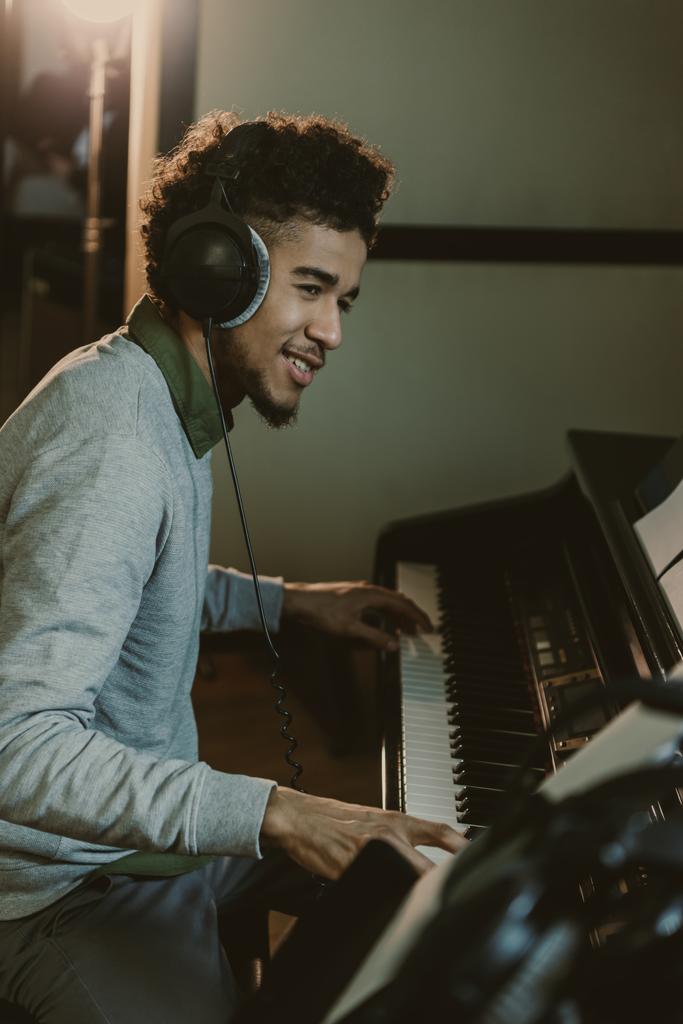 happy young african american man playing piano at studio - Photo, Image