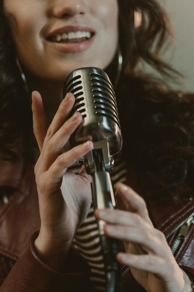 ビンテージ マイクを使って歌を実行する女性歌手のショットをトリミング - 写真・画像
