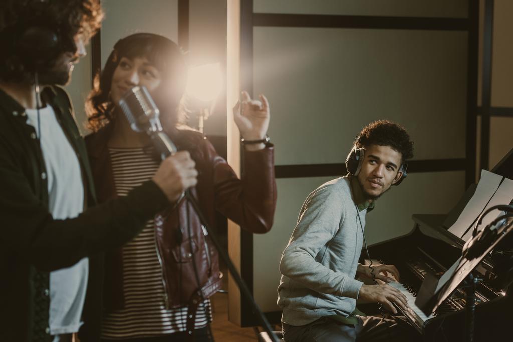 fiatal pár dal végezhette mikrofon, míg a férfi játszik a zongora mögött - Fotó, kép