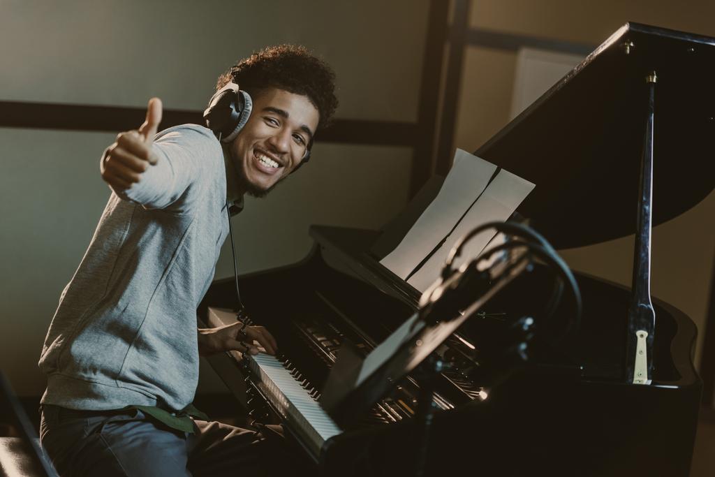 šťastný mladý klavírista ukazuje palec - Fotografie, Obrázek