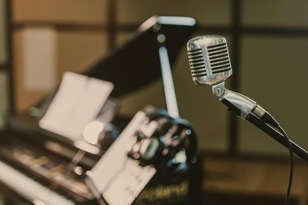 close-up shot of vintage microphone in front of blurred piano - Photo, Image