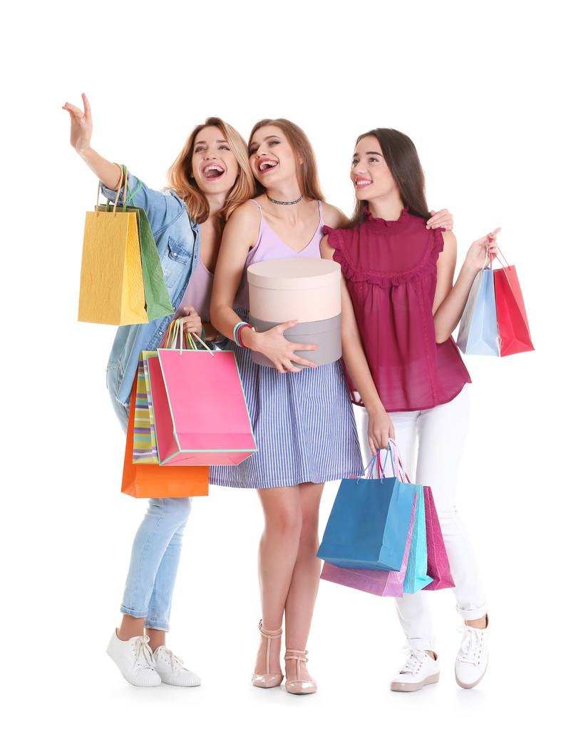 Mujeres jóvenes felices con bolsas de compras y cajas sobre fondo blanco
 - Foto, Imagen