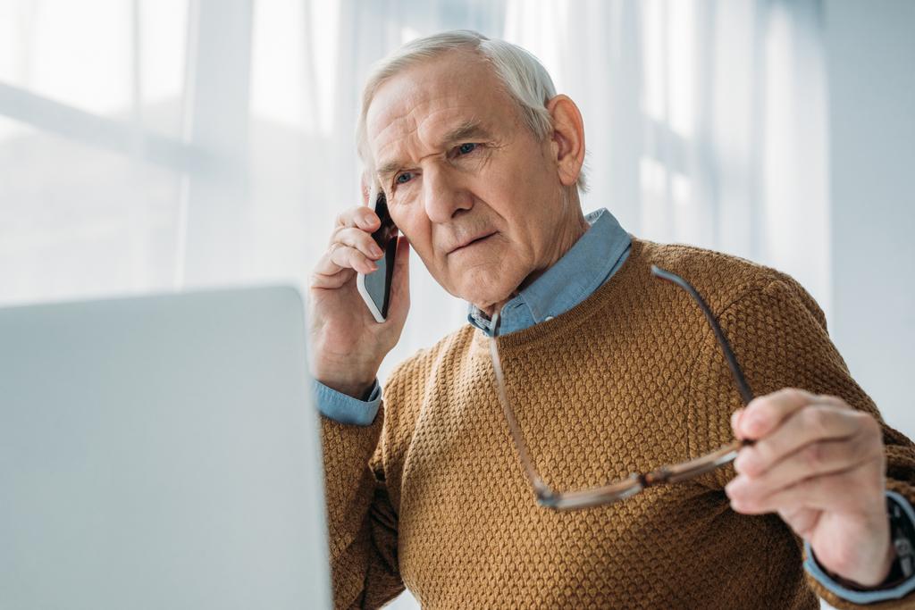 Vanhempi kiireinen mies työskentelee toimistossa ja soittaa puhelun
 - Valokuva, kuva