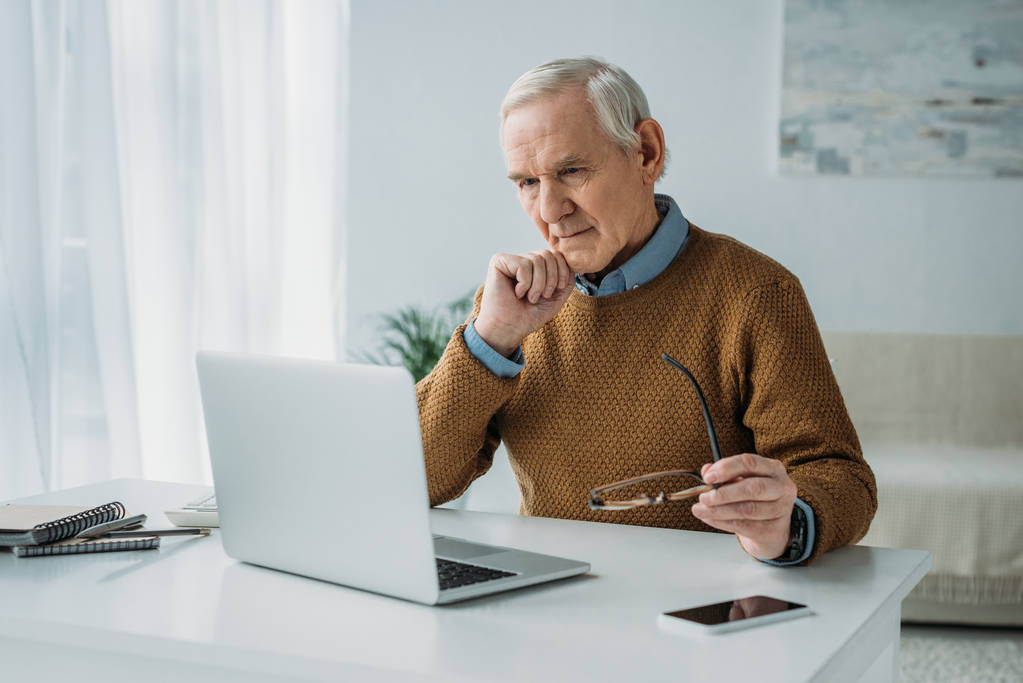 Uomo anziano fiducioso che lavora sul computer portatile
 - Foto, immagini