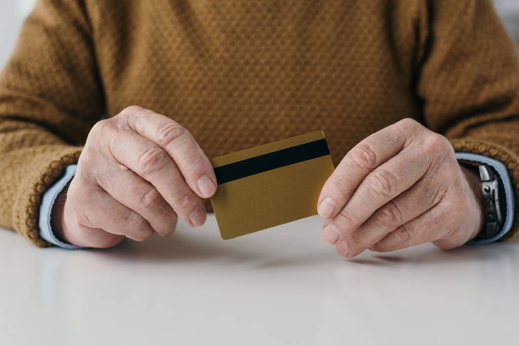 Vue rapprochée du sénior titulaire d'une carte de crédit
 - Photo, image