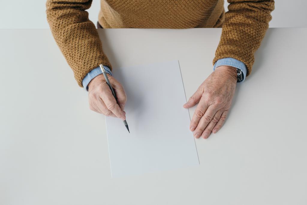 Vista de cerca del hombre mayor escribiendo en papel en blanco
 - Foto, Imagen