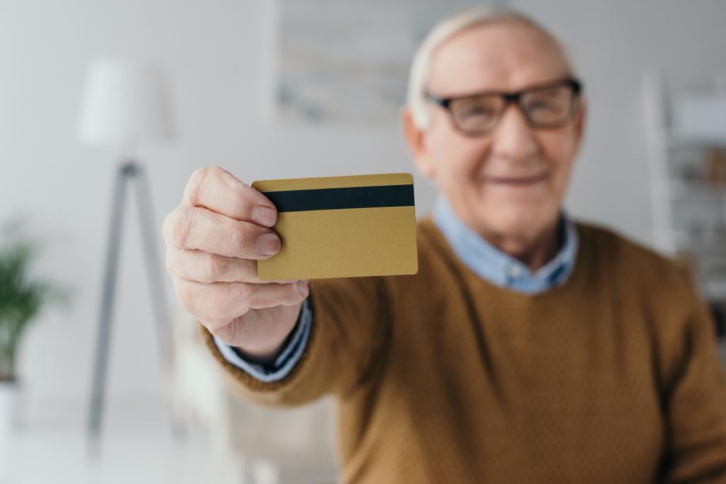 Uomo anziano sorridente in possesso di carta di credito
 - Foto, immagini