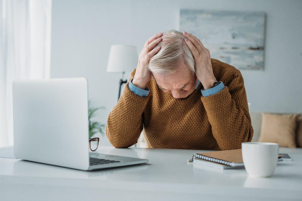 Homme âgé travaillant au bureau et souffrant de maux de tête
 - Photo, image