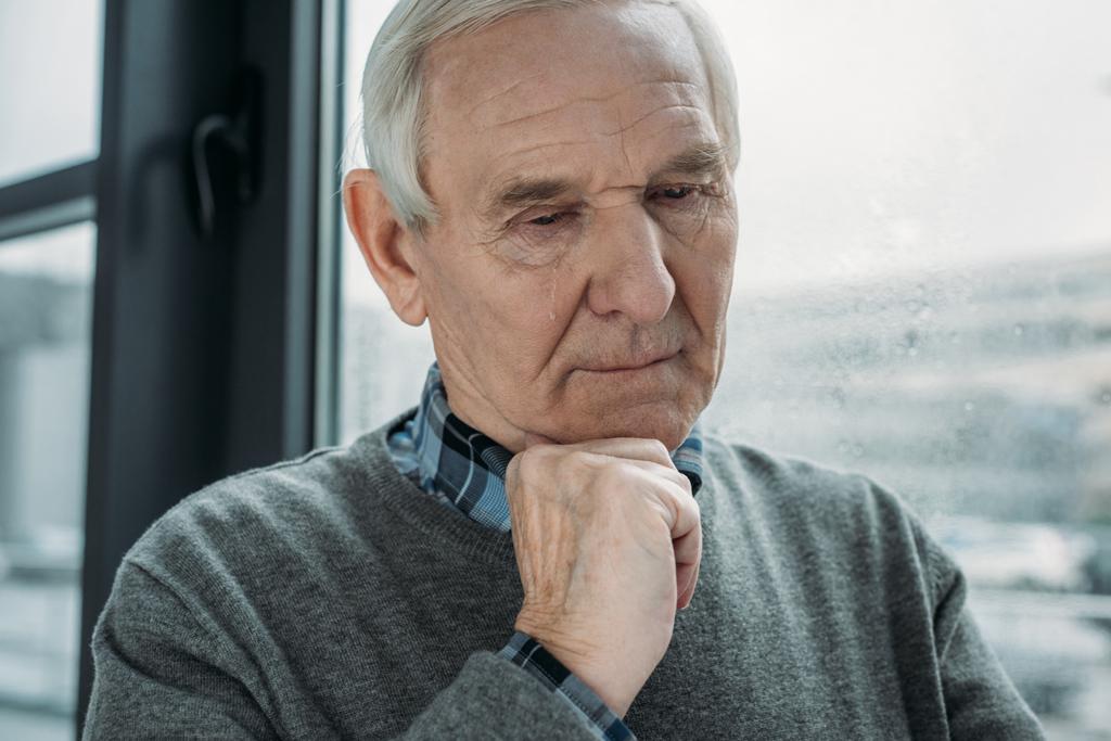 Senior nadenkende man met droevige uitdrukking huilt  - Foto, afbeelding