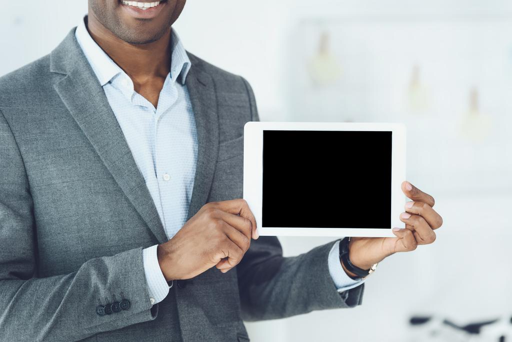περικομμένη εικόνα του χαμογελώντας αφρικανική αμερικανική άνθρωπος που δείχνει tablet - Φωτογραφία, εικόνα