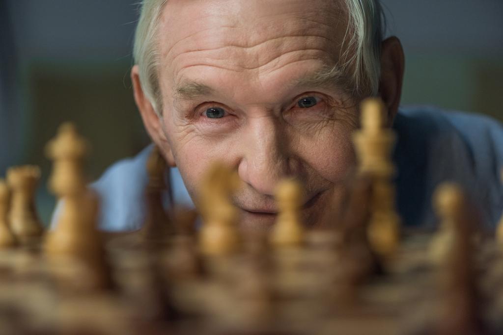 Ανώτερος αυτοπεποίθηση άνθρωπος κοιτάζει το σκάκι του σκάφους - Φωτογραφία, εικόνα