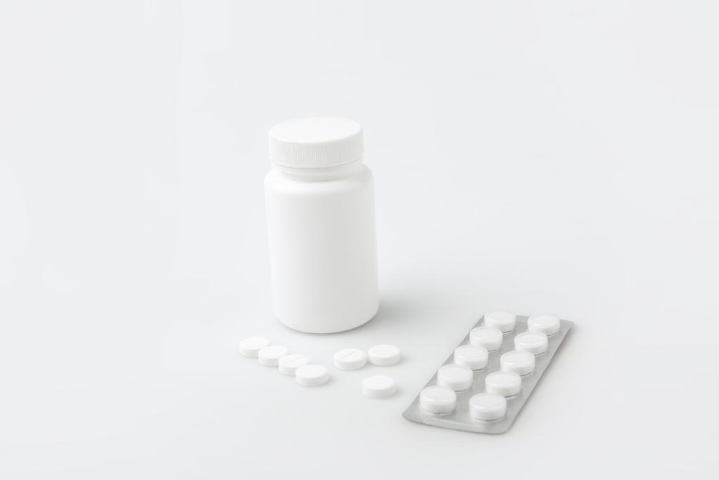 envase, píldoras dispersas y tabletas en el paquete aislado sobre fondo blanco
    - Foto, Imagen