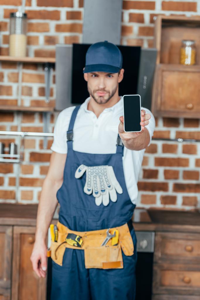 красивый молодой профессиональный домашний мастер показывает смартфон с чистым экраном
 - Фото, изображение