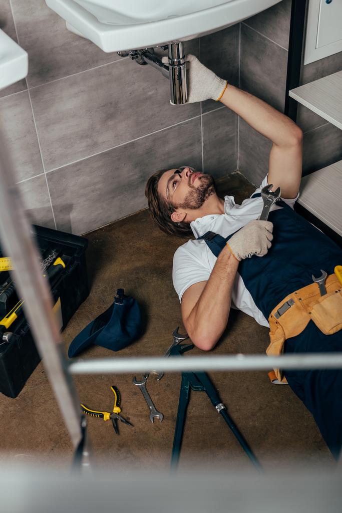 Selektivní fokus mladých mužů instalatér upevnění dřezu v koupelně - Fotografie, Obrázek