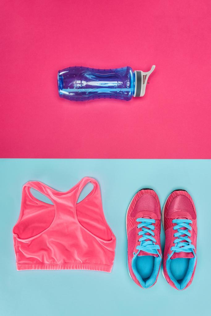 Спортивне обладнання з взуттям, пляшкою води та спортивним верхом ізольовано на рожевому та синьому
 - Фото, зображення