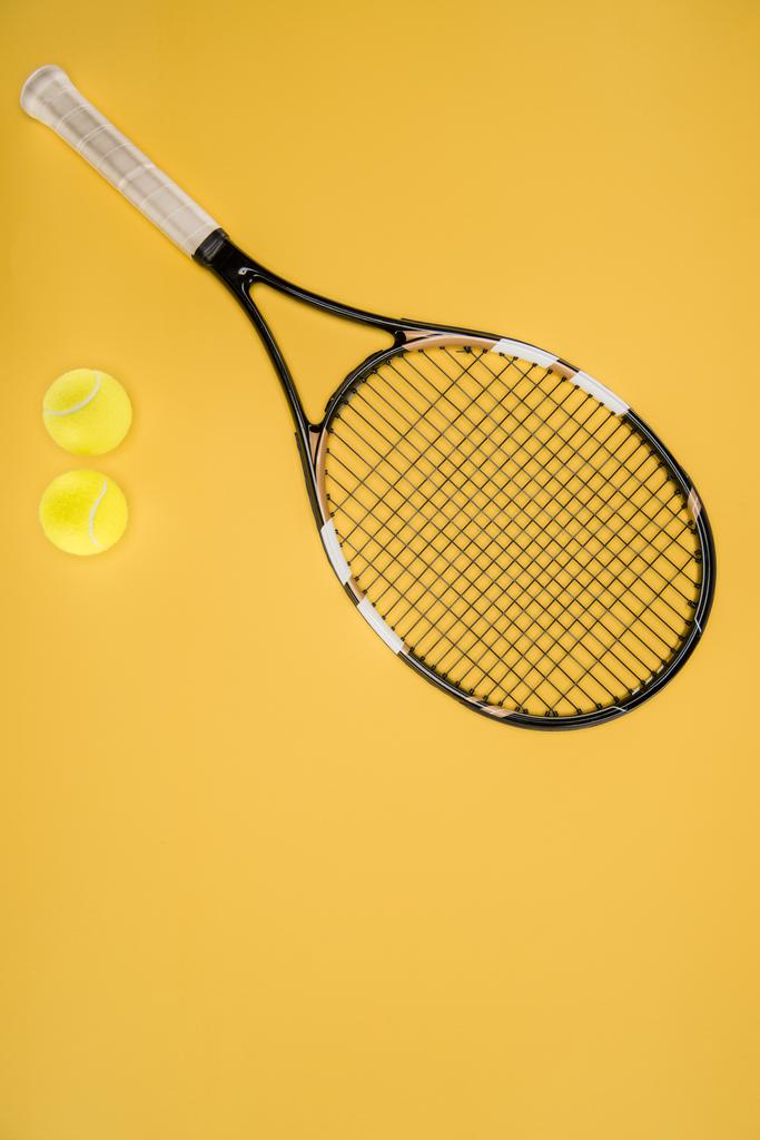 Tennis racket with balls isolated on yellow - Photo, Image