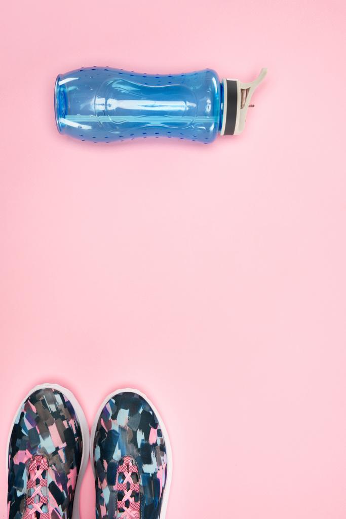 Sport cipő és a vizes palack rózsaszín elszigetelt - Fotó, kép