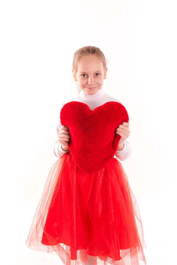 Linda niña sosteniendo corazón rojo aislado
 - Foto, imagen