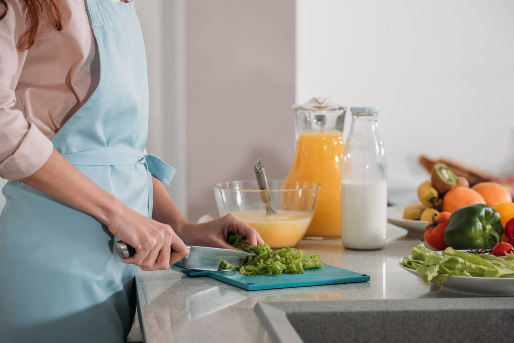 immagine ritagliata di donna che taglia verdure per insalata
 - Foto, immagini