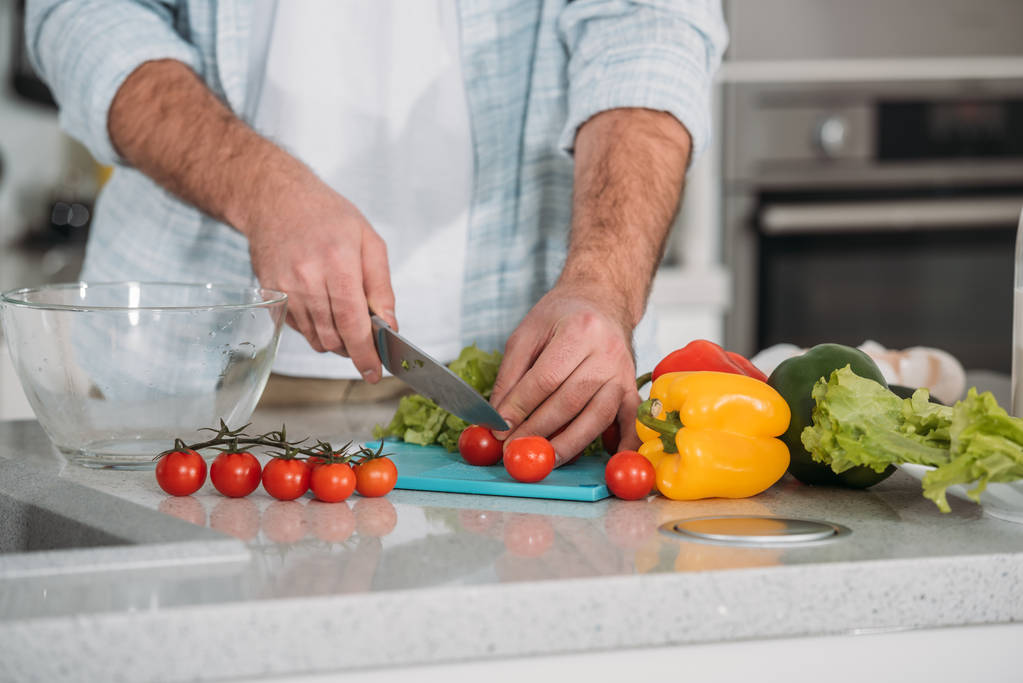 przycięty obraz człowieka krojenia warzyw na sałatkę - Zdjęcie, obraz
