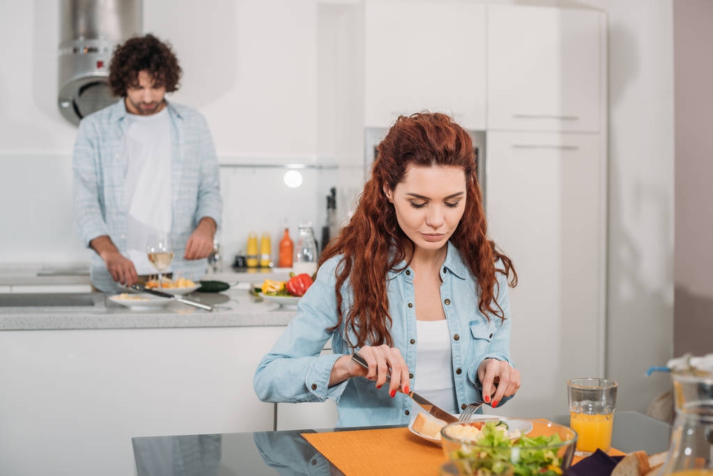 fidanzata mangiare mentre fidanzato cucina in cucina
 - Foto, immagini