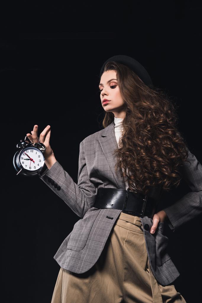 κομψά μοντέρνα νεαρή γυναίκα κρατώντας ρολόι που απομονώνονται σε μαύρο - Φωτογραφία, εικόνα