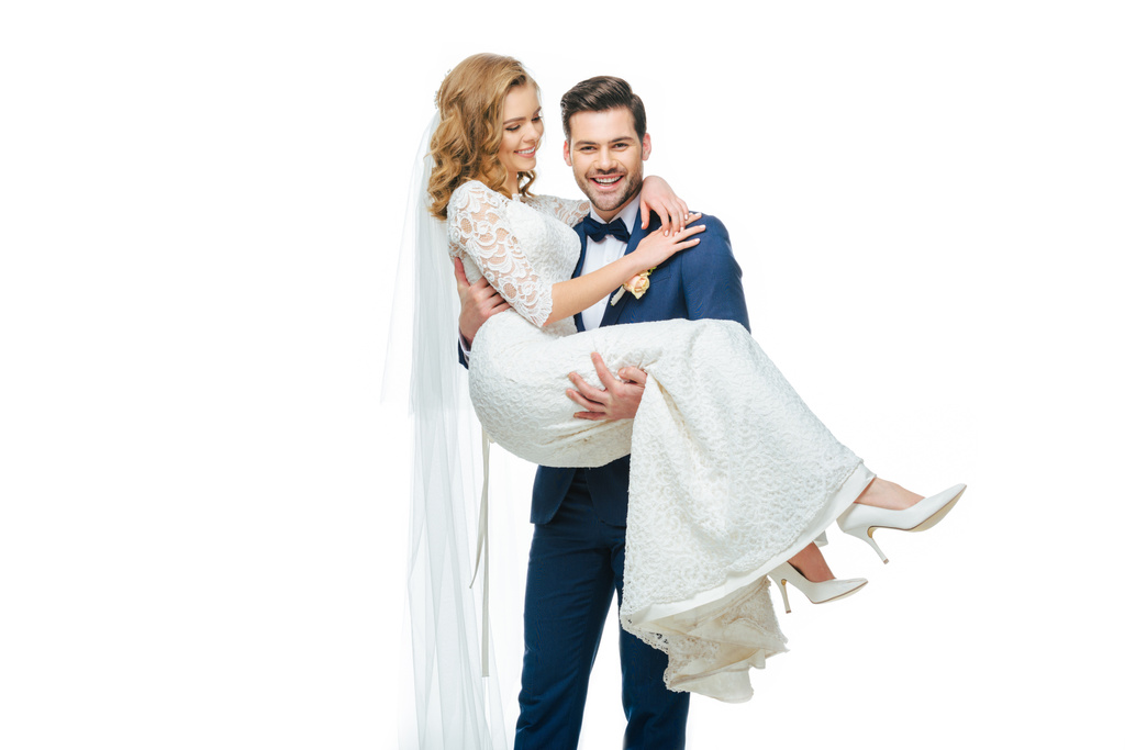 mladý ženich drží krásná nevěsta na rukou izolované na bílém - Fotografie, Obrázek