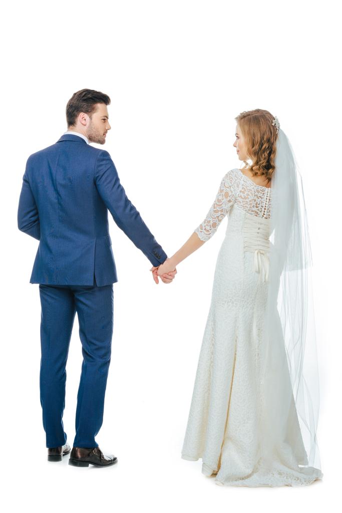 back view of beautiful wedding couple holding hands isolated on white - Photo, Image
