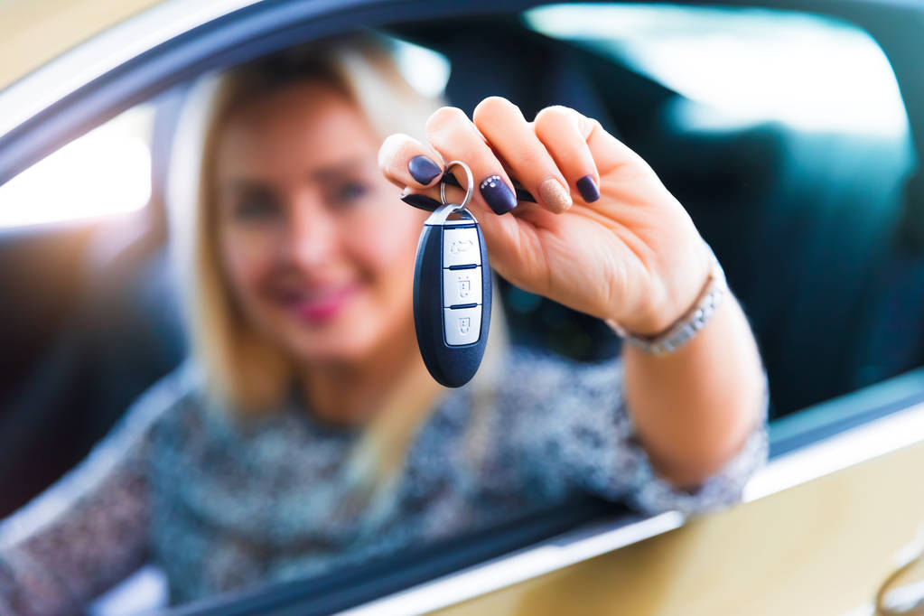 Ευτυχισμένη γυναίκα οδηγός κρατώντας κλειδιά αυτοκινήτου στο αυτοκίνητό της - Φωτογραφία, εικόνα