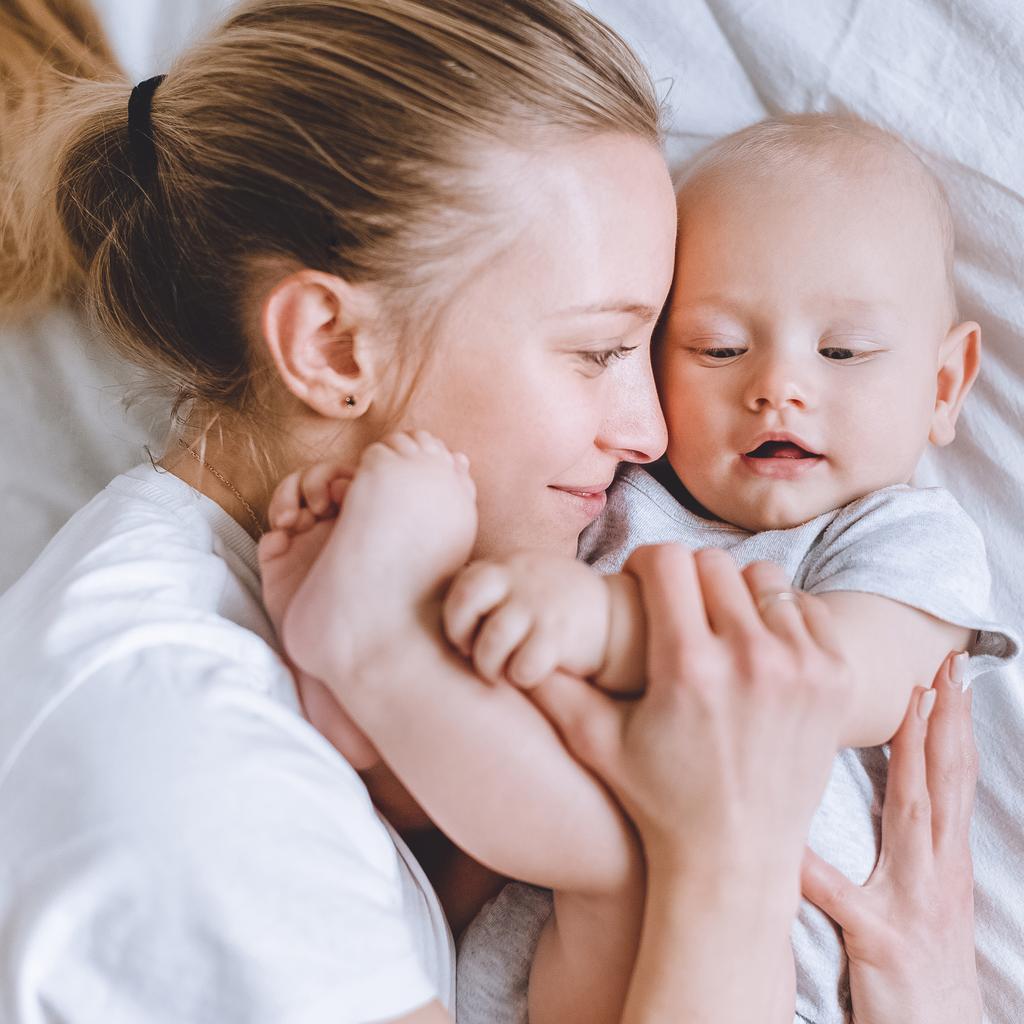 gros plan de la jeune mère embrassant son enfant au lit
 - Photo, image
