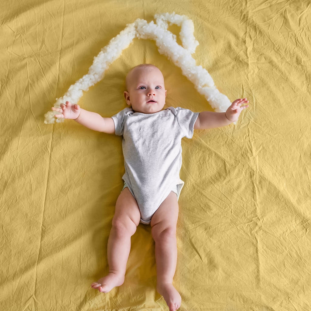Blick von oben auf Säugling unter Dach aus Baumwolle im Bett - Foto, Bild