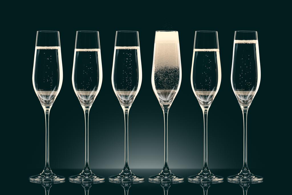 sechs transparente Gläser mit Champagner auf schwarz - Foto, Bild