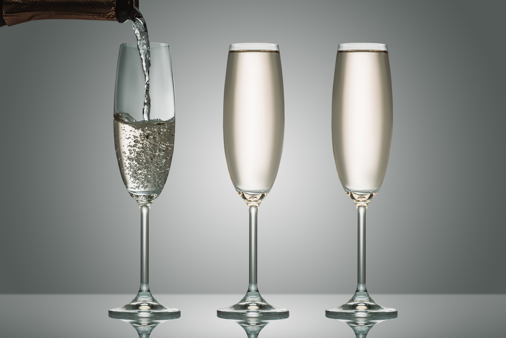 derramando champanhe de garrafa em três copos em cinza
 - Foto, Imagem