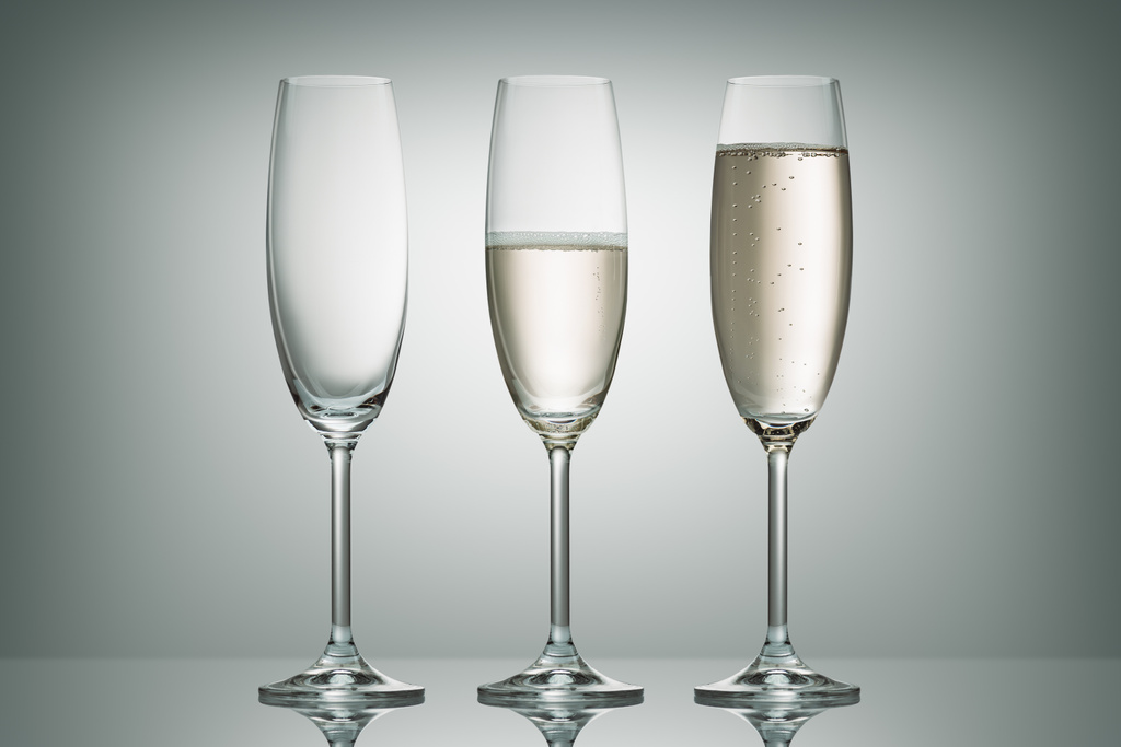 tres copas con diferente nivel de champán en blanco
 - Foto, Imagen
