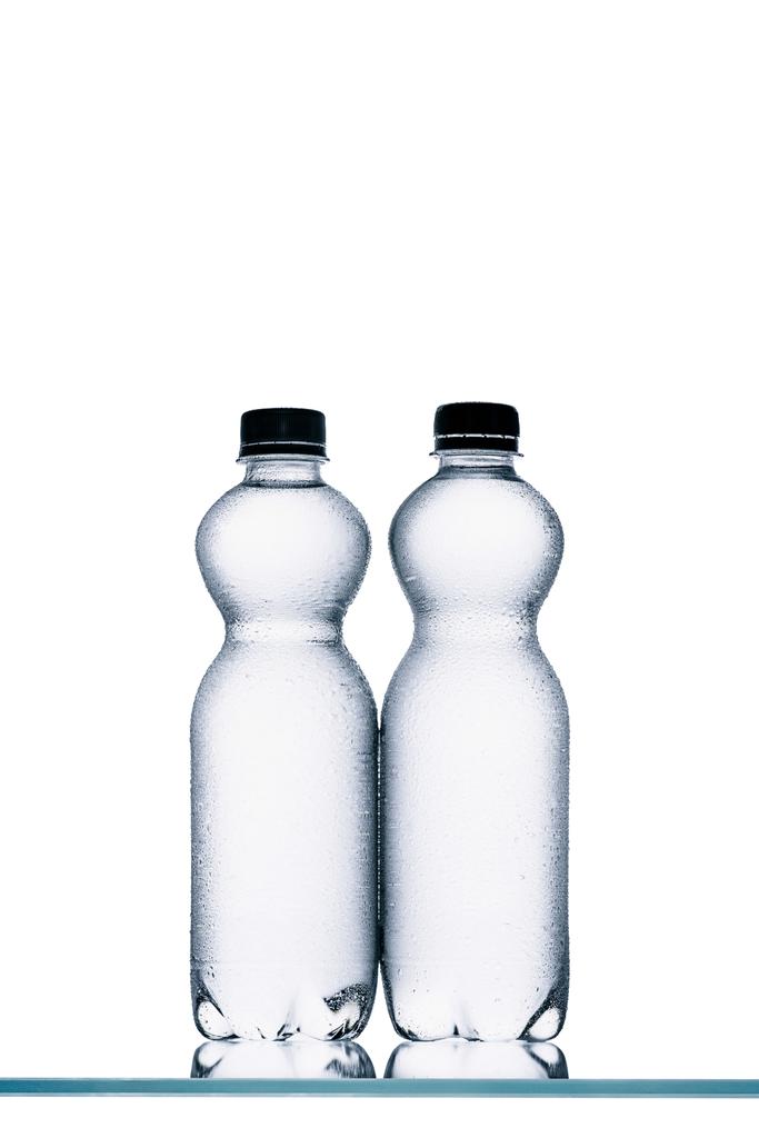 natte plastic flessen water geïsoleerd op wit - Foto, afbeelding