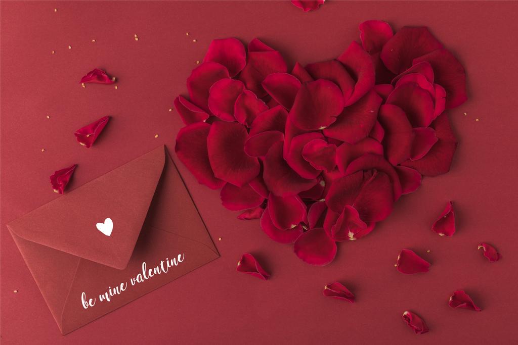 κάτοψη της καρδιάς από τριαντάφυλλα πέταλα και φάκελος που απομονώνονται σε κόκκινο, Αγίου Βαλεντίνου έννοια - Φωτογραφία, εικόνα