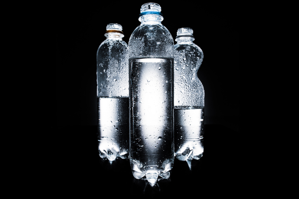 διάφορα πλαστικά μπουκάλια νερού στο σκοτάδι  - Φωτογραφία, εικόνα