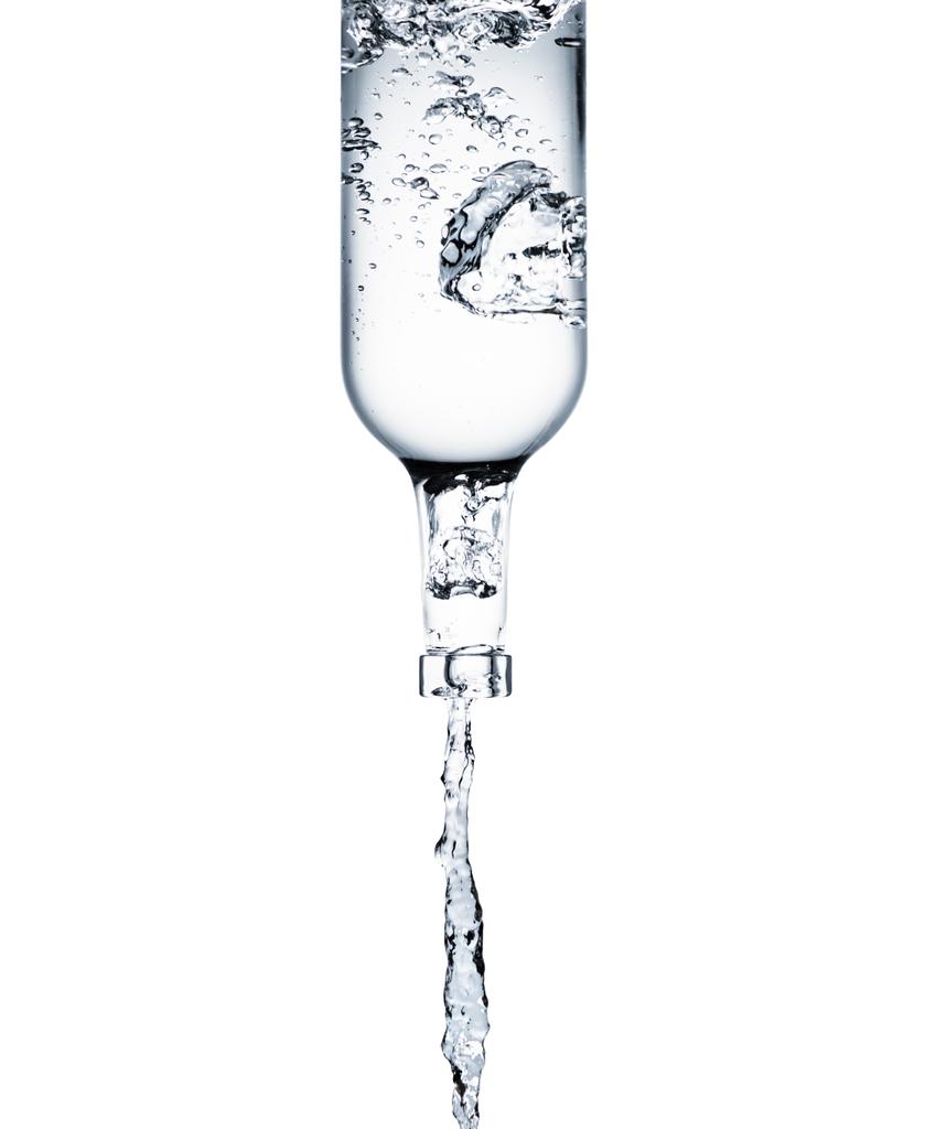 sauberes Wasser aus Glasflasche isoliert auf weiß gießen - Foto, Bild
