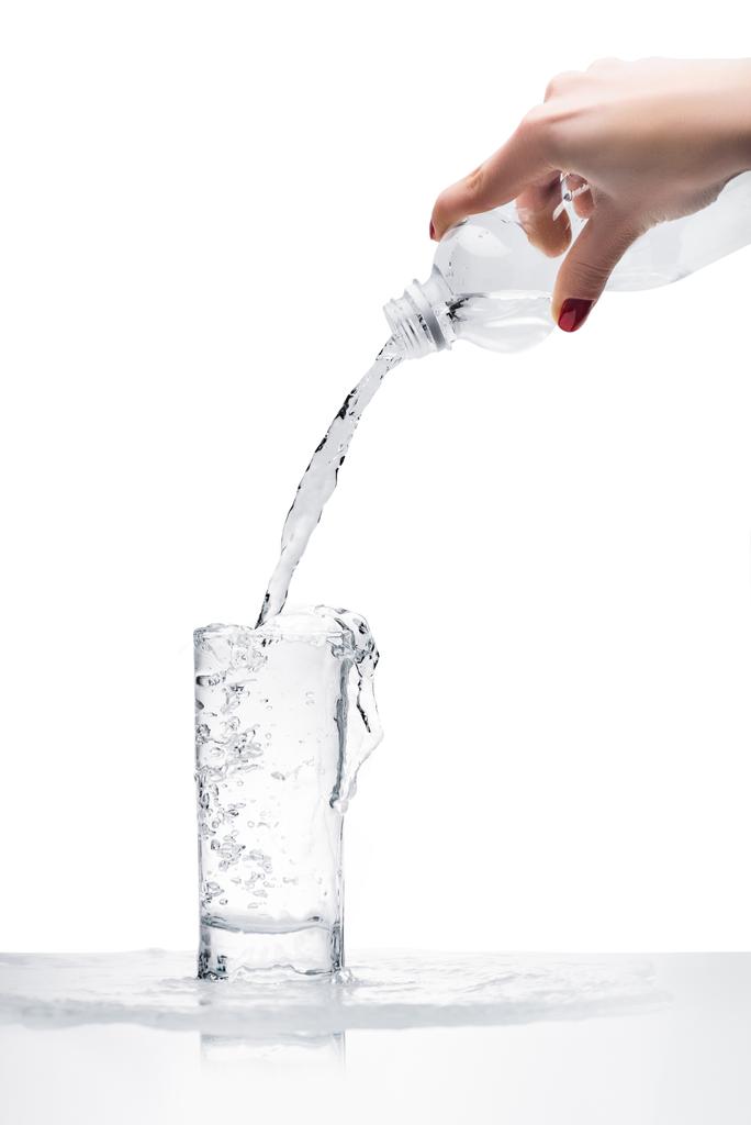 plan recadré de la femme verser de l'eau dans le verre de bouteille en plastique isolé sur blanc
 - Photo, image