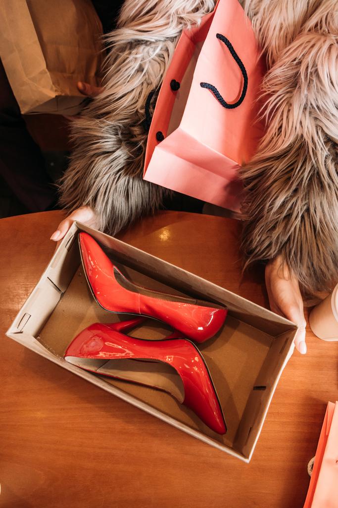 Colpo ritagliato di donna alla moda in pelliccia appendiabiti scatola con scarpe con tacco alto rosso alla moda
 - Foto, immagini