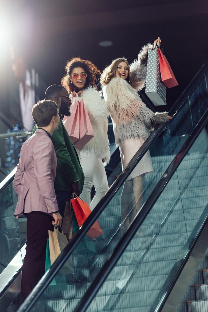 молода стильна група покупців на ескалаторі в торговому центрі
 - Фото, зображення