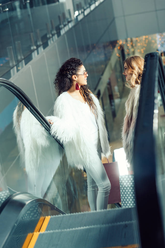 les jeunes femmes parlent sur l'escalator au centre commercial
 - Photo, image