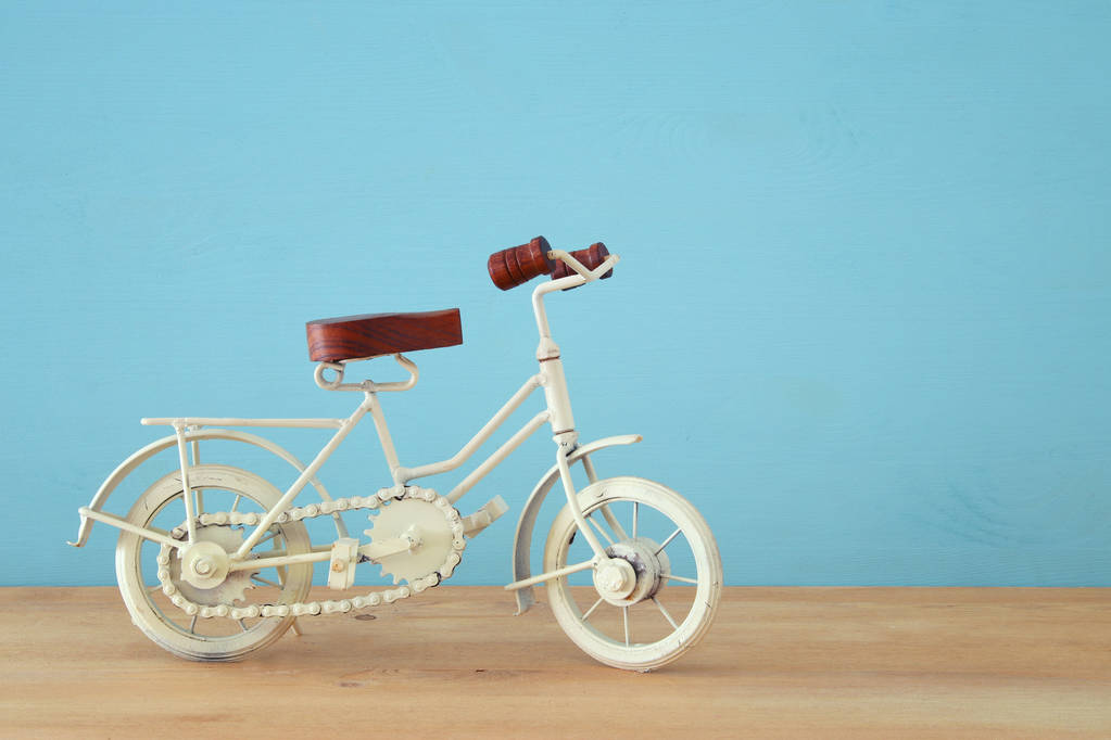 Vintage fém fehér kerékpár játék fából készült asztal fölé. - Fotó, kép