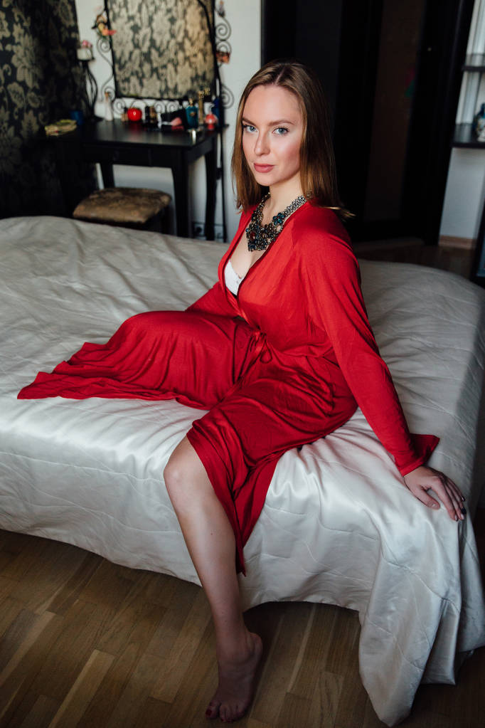 Bella signora sexy in elegante accappatoio rosso. Ritratto di moda di modella all'interno
. - Foto, immagini