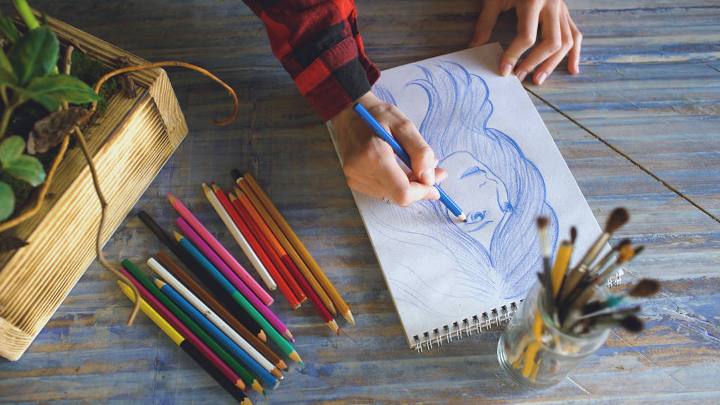 Крупним планом жіночий малюнок рук на паперовому блокноті з олівцями. Жінка-художник на роботі
 - Фото, зображення