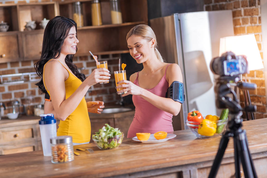 Mujeres felices positivas bebiendo jugo fresco
 - Foto, Imagen