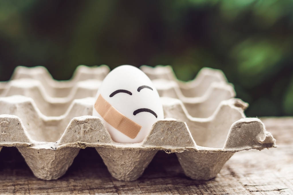 zerbrochenes Ei mit festklebendem Gips. Konzept der Sprödigkeit und Pai - Foto, Bild