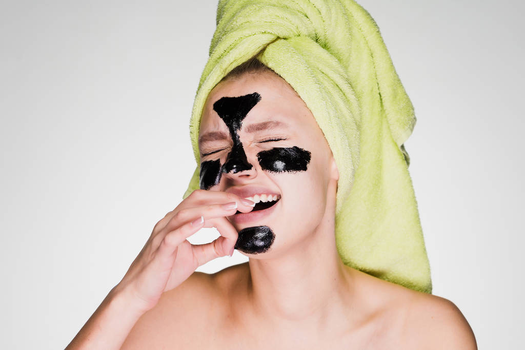 menina triste com uma toalha na cabeça remove uma máscara preta de seu rosto, dói
 - Foto, Imagem